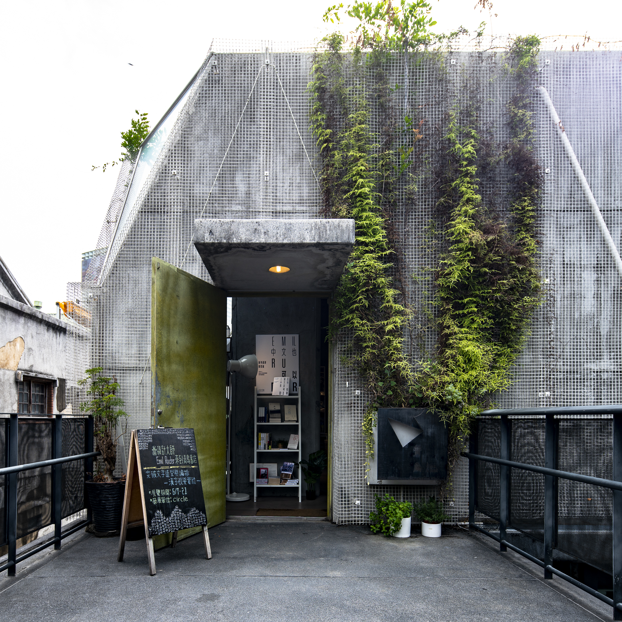 華山青鳥入口,金屬網格外牆與綠意構成書店的第一個風景